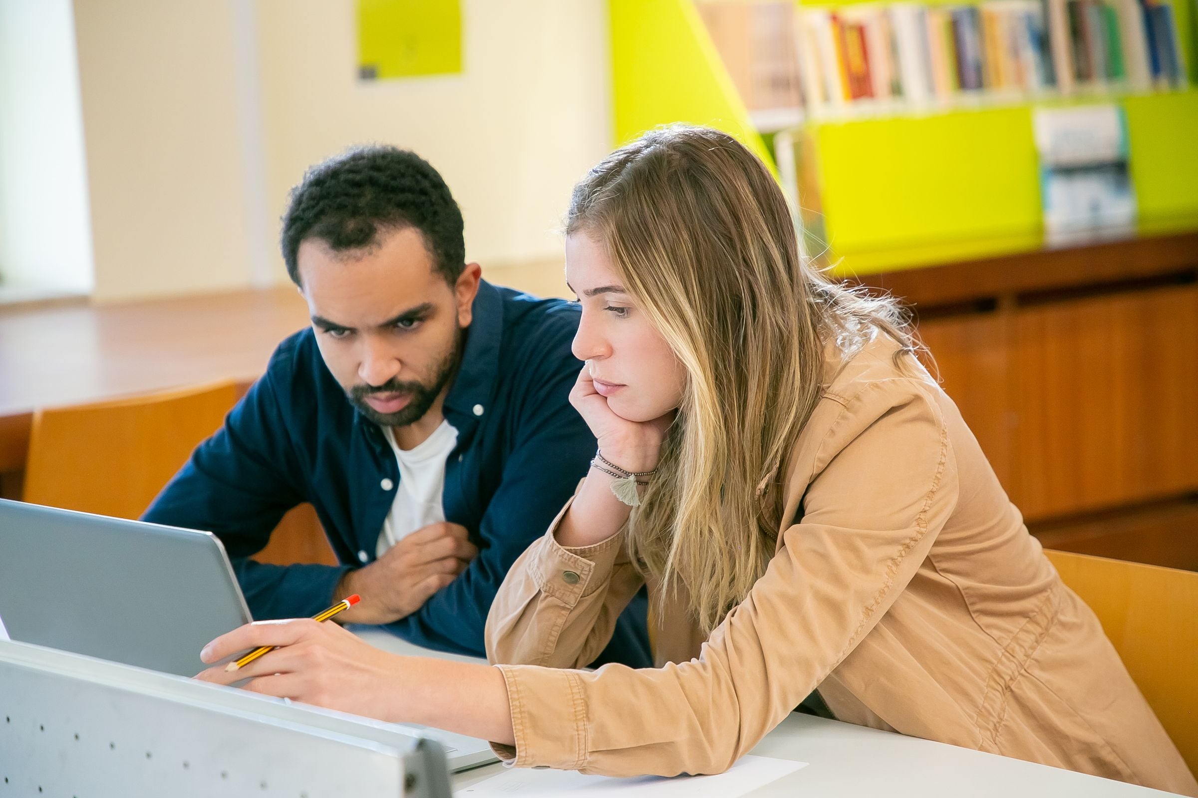 Two students studying together on a laptop