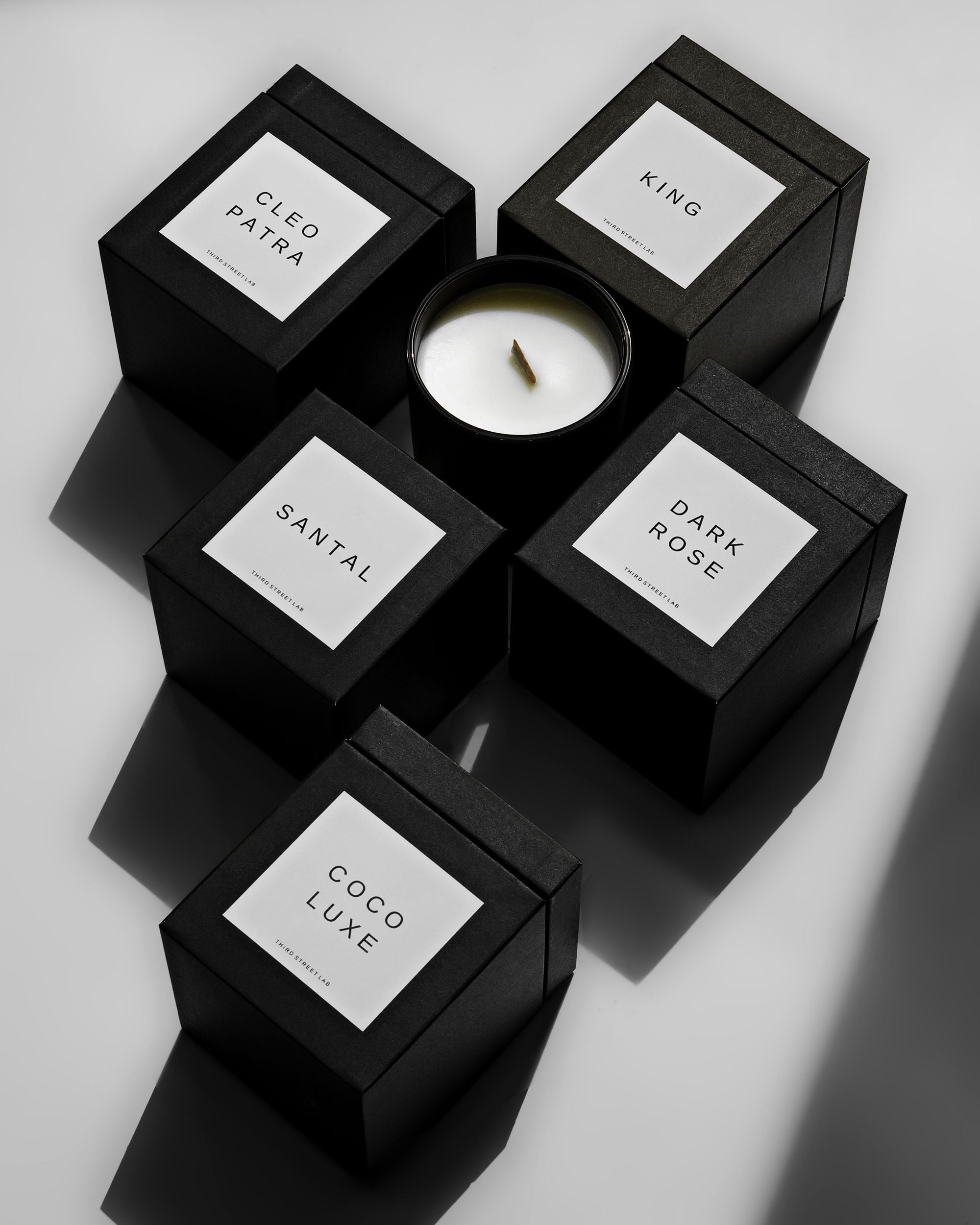 Minimal black candle boxes with clean typographic labels