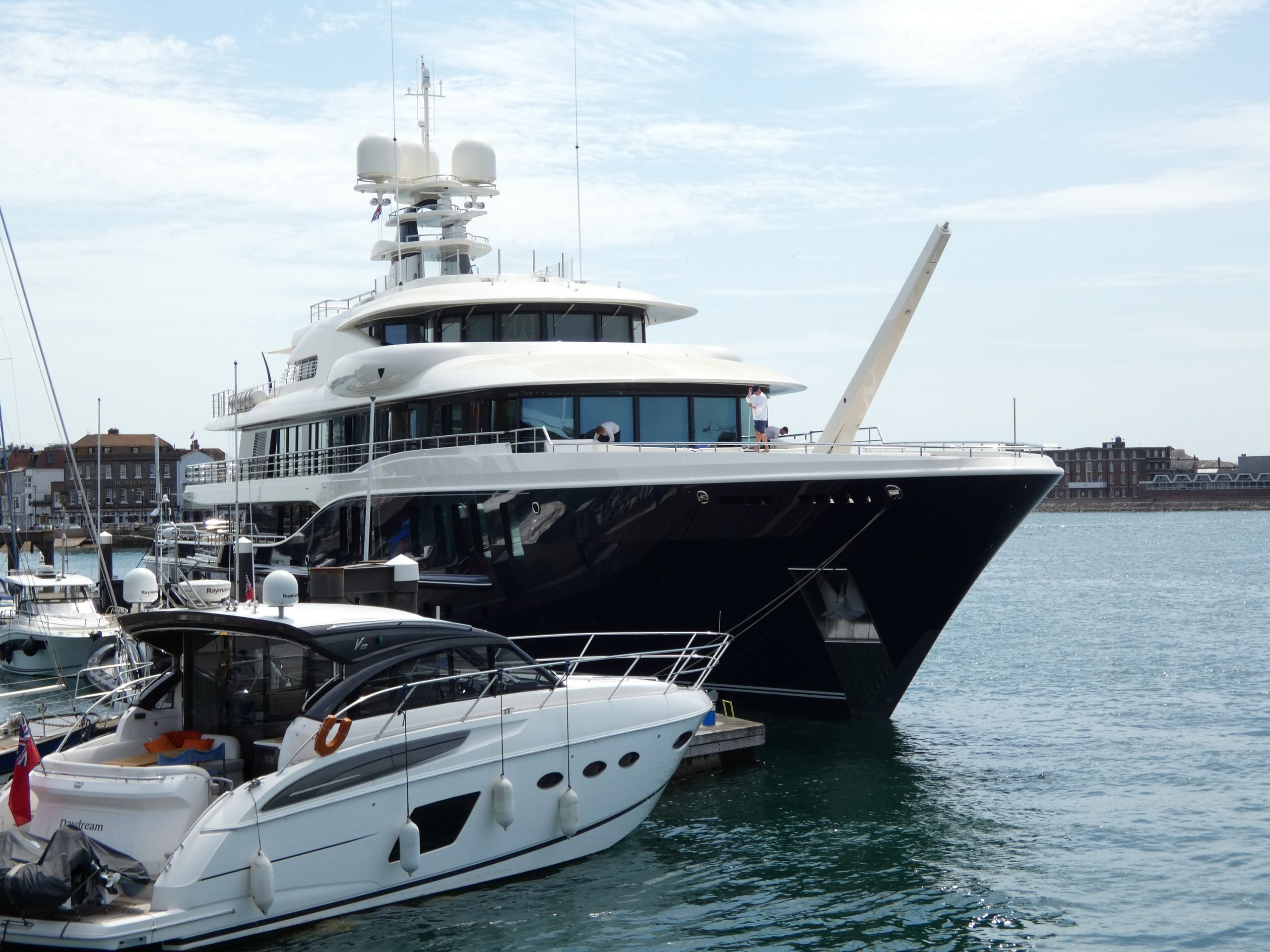 Luxury yacht moored at a marina under a clear sky