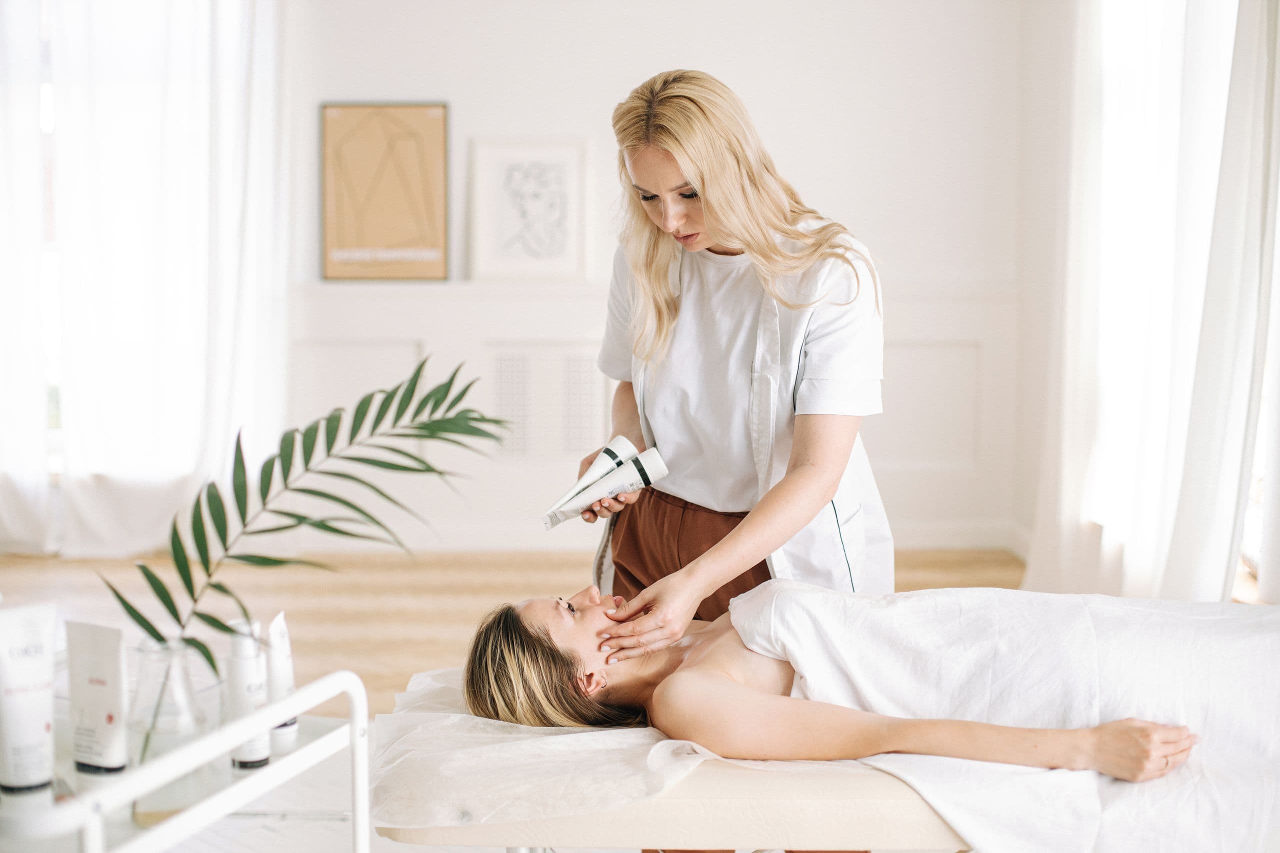 A practitioner treating a client in a bright, calm aesthetics clinic