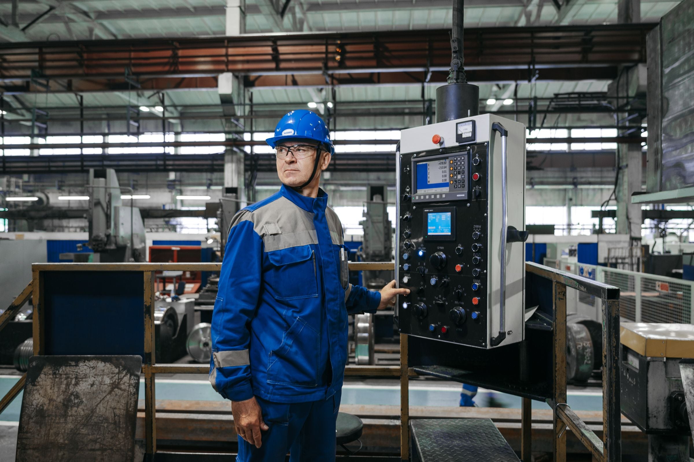 An engineer operating a machine control panel in a factory