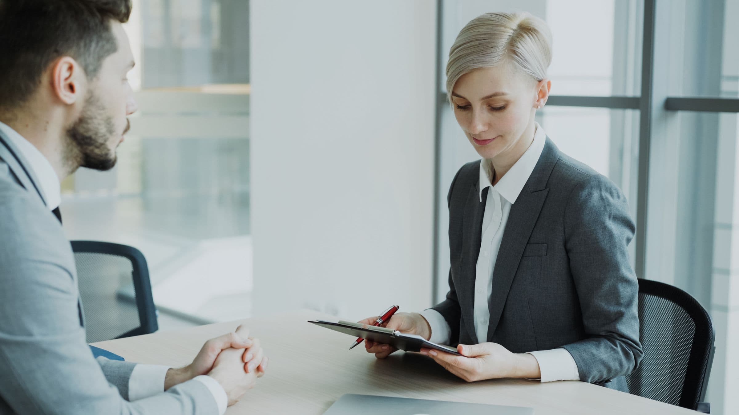Two professionals talking across a table in an interview