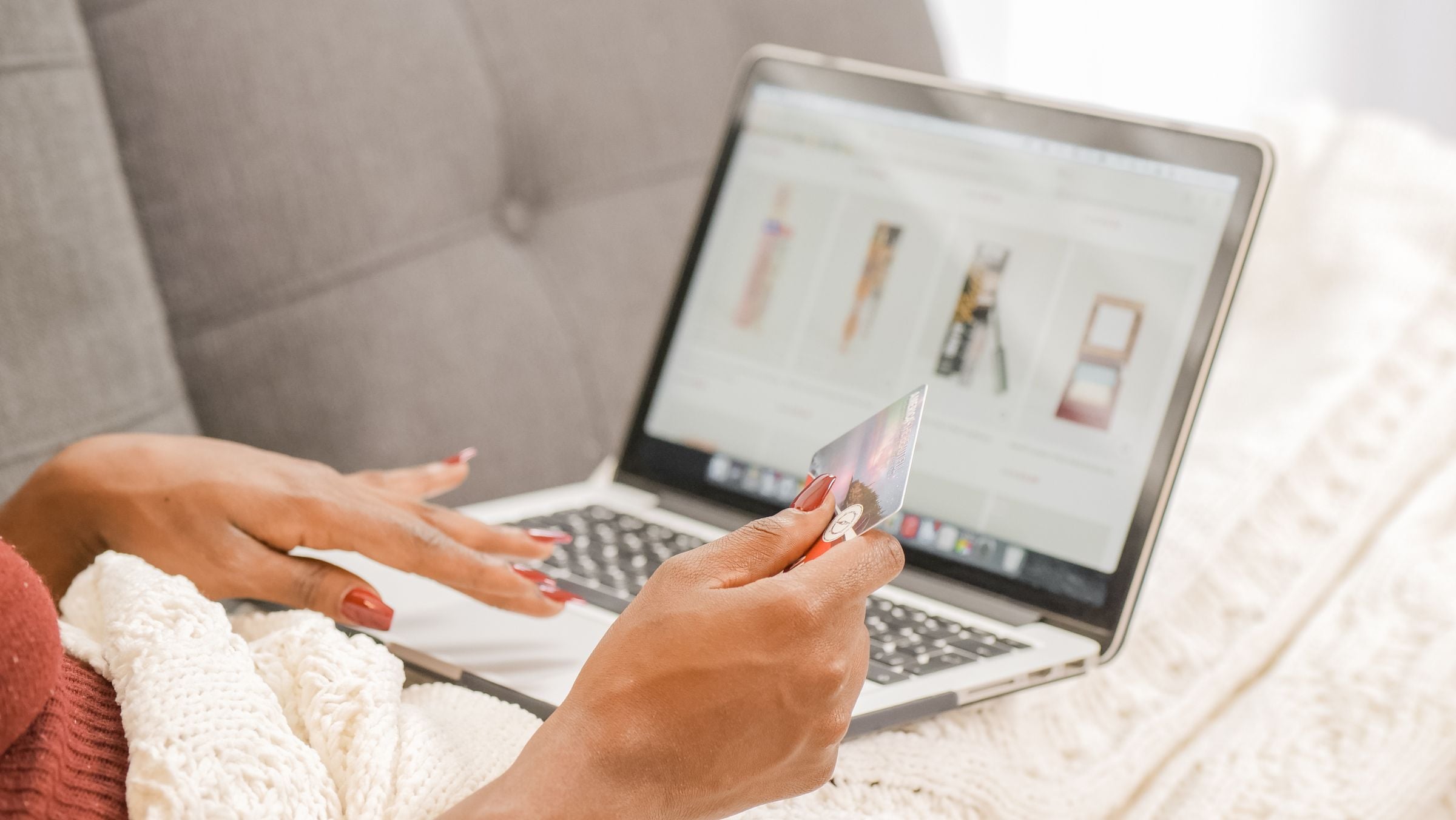 A woman shopping online on a laptop with a credit card